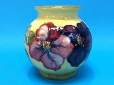 A Moorcroft globular vase on a pale yellow ground, decorated with pansies, signed, impressed