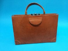 A late 1940's brown leather vanity case of triangular design, opening to reveal a fitted interior