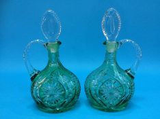 A pair of light green and clear glass decanters