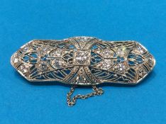 A diamond encrusted white metal brooch