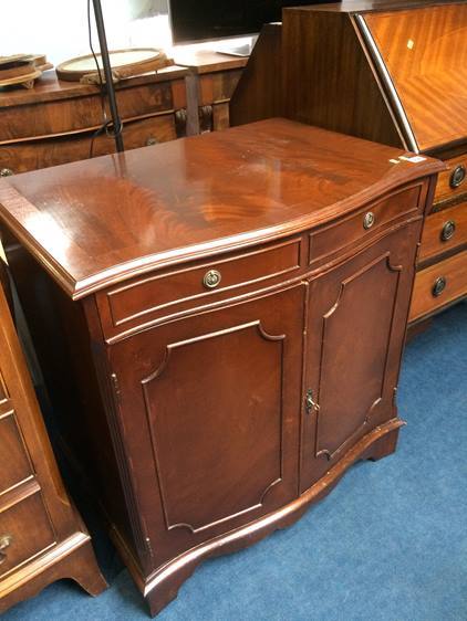 A reproduction mahogany serpentine cabinet