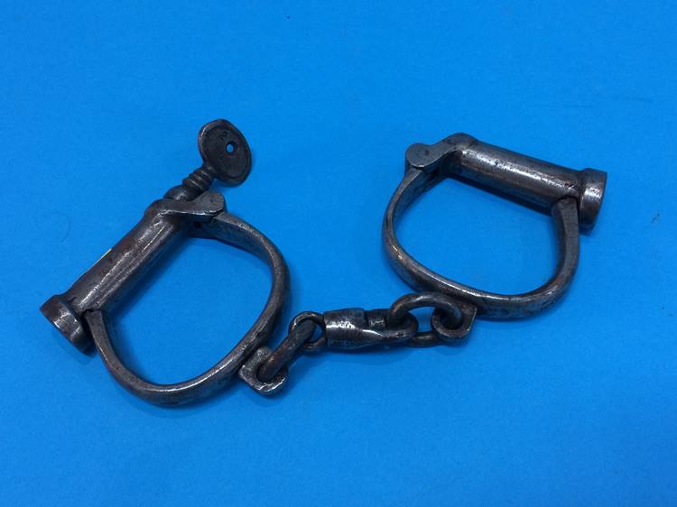 A pair of antique hand cuffs