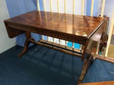 A reproduction mahogany drop leaf coffee table