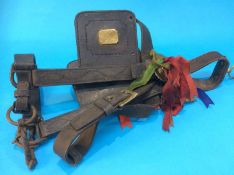 An antique leather horse bridle and brasses