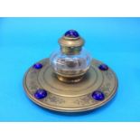 A Victorian cut glass and brass ink well mounted with blue enamelled cabochons