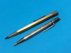 A silver propelling pencil and a similar gold plated pencil