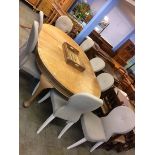 A large oak oval extending dining table and eight chairs