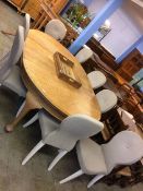 A large oak oval extending dining table and eight chairs