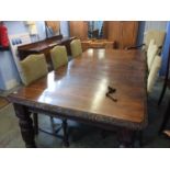 An early 20th century carved oak wind out dining table with carved edge, supported on carved