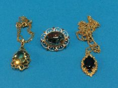 Two gold mounted pendants with chains and a gold mounted brooch