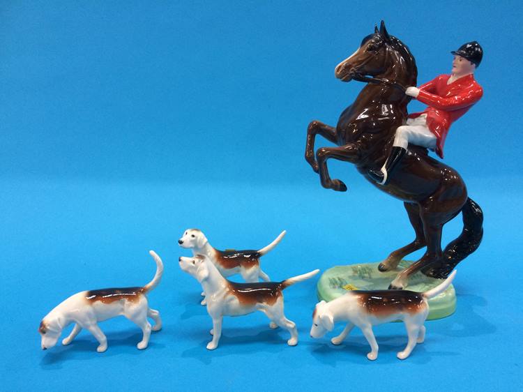 A Beswick huntsman on a rearing horse and four hounds