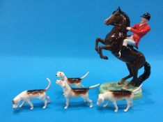 A Beswick huntsman on a rearing horse and four hounds