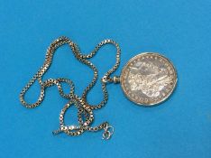 A silver dollar mounted as a pendant