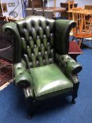 A green leather button back wing chair