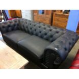 A black Chesterfield settee