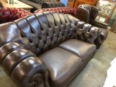 A large brown leather Chesterfield settee and armchair