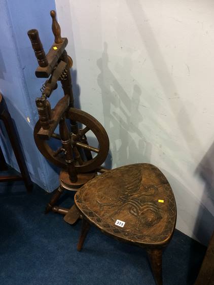 A spinning wheel and carved top occasional table