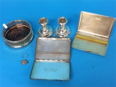 A plated wine coaster, pair of dwarf candlesticks and two silver cigarette cases