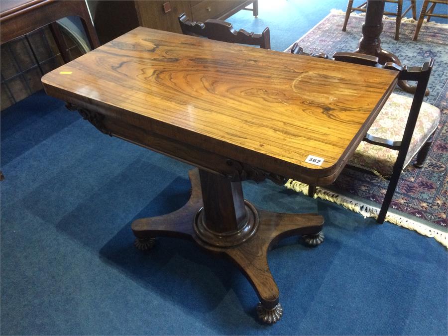 A William IV rosewood fold over tea table, with octagonal supports and quadruple base