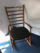 A teak ladderback rocking chair