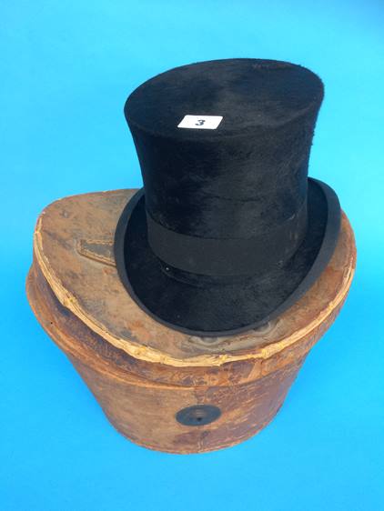 A leather top hat case with top hat