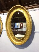 A large gilt oval mirror
