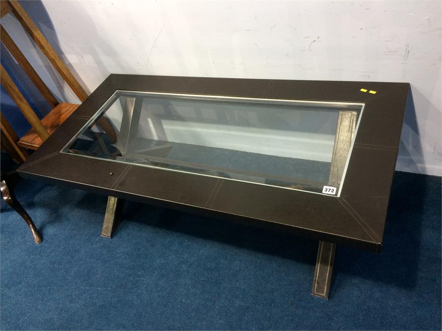 A modern leather and glass top coffee table