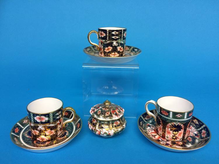 A Royal Crown Derby Imari pill box and three Royal Crown Derby coffee cans and saucers