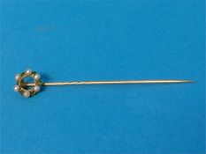 A yellow metal pin, mounted with seed pearls