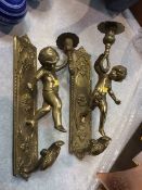 A pair of brass cherub sconces