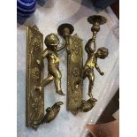 A pair of brass cherub sconces