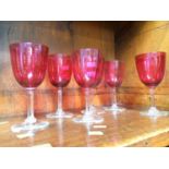 Six cranberry coloured glasses