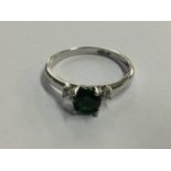White metal ring, mounted with emerald coloured stone, stamped '750'
