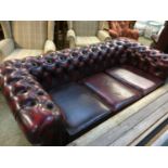 An oxblood Chesterfield three seater settee