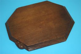 A Robert 'Mouseman' Thompson of Kilburn dark oak octagonal cheeseboard. 30 cm wide