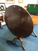 A mahogany circular tilt top table