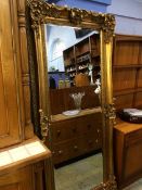 A large gilt ornate mirror, 193cm length, 88cm wide