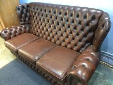 A brown leather Chesterfield three seater settee