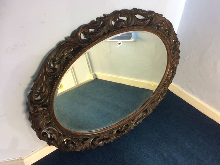 Oval mirror in carved oak frame