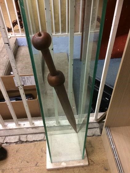 A cast foot resting upon a glass display cabinet containing a sword - Image 3 of 6