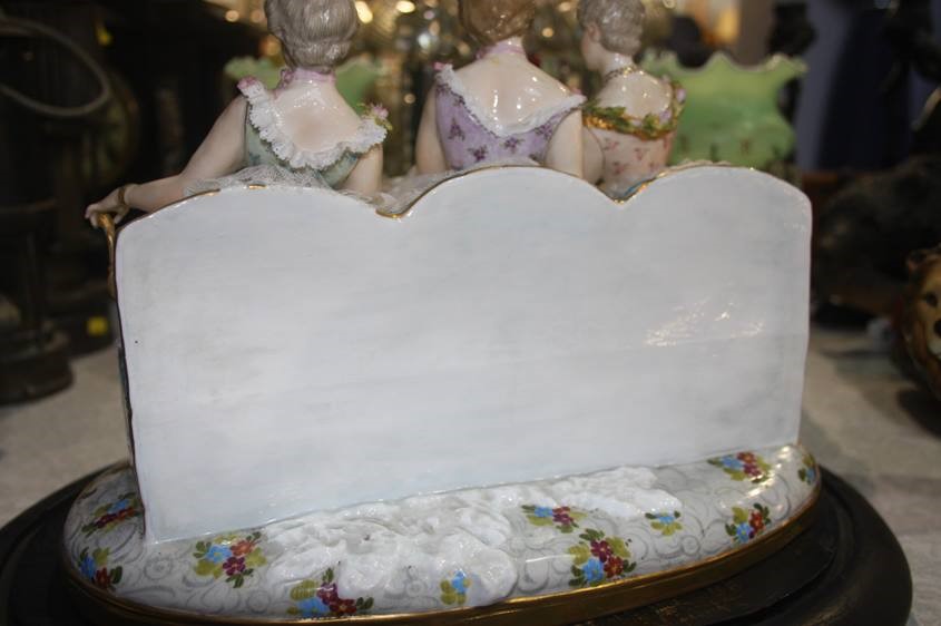 A late 19th century Continental porcelain group of three young Ladies seated on a bench, under a - Image 7 of 8