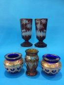 A pair of red acid etched Bohemian glass goblets, a pair of blue glass and enamelled vases and a