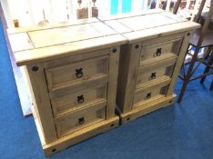 A pair of pine bedside three drawer chests