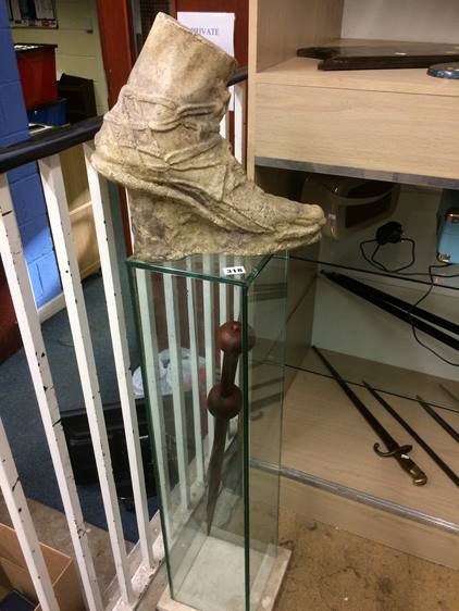 A cast foot resting upon a glass display cabinet containing a sword - Image 4 of 6