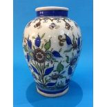 An Iznik/Islamic pottery ovoid shape vase, decorated with sprays of flowers with blue banding. 23 cm