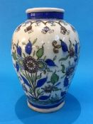 An Iznik/Islamic pottery ovoid shape vase, decorated with sprays of flowers with blue banding. 23 cm