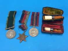 Two silver mounted cheroot holders and a World War II trio