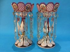 A pair of 19th Century Bohemian cranberry coloured glass lustres, the bodies overlaid with white and