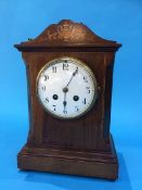 An Edwardian mahogany mantel clock with enamelled dial, 8 day movement and strike action. 29 cm