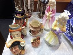 Five Royal Doulton jugs and a pair of Royal Doulton figures